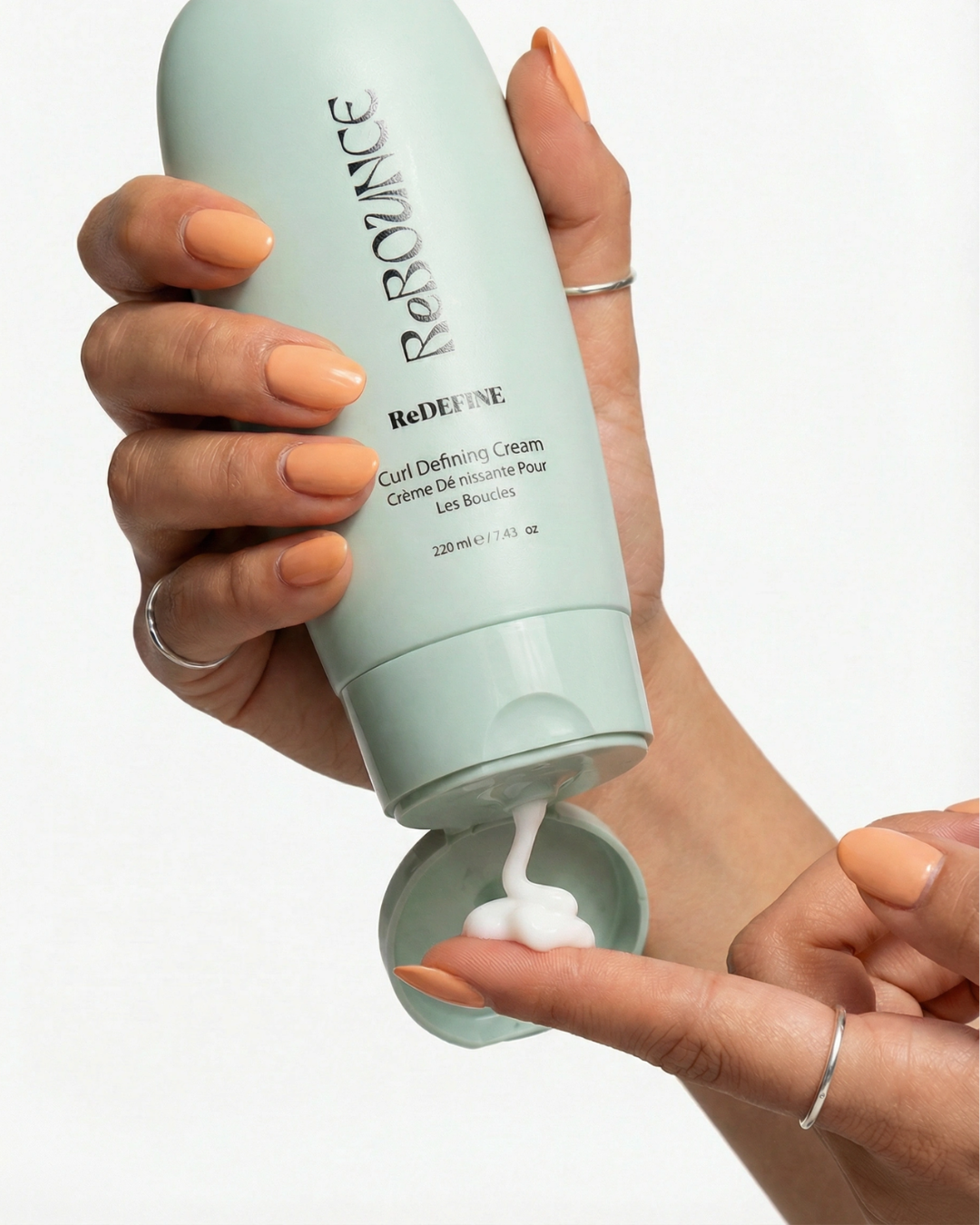 Person holding a bottle of 'Rebounce' cream with visible cream being squeezed out.